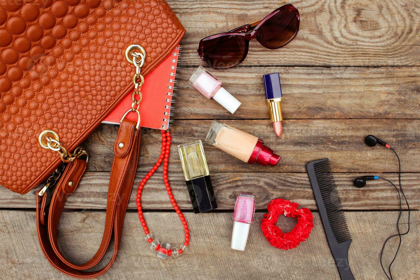 Things from open lady handbag. women's purse on wood background. Toned image. photo