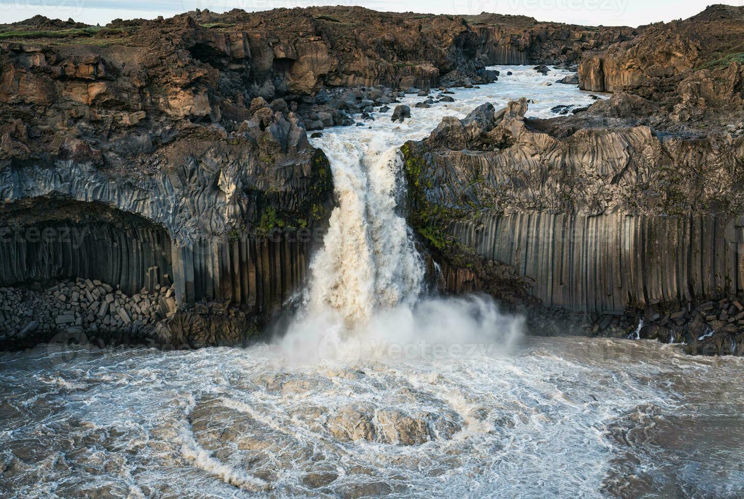 Powerful Aldeyjarfoss waterfall flowing from ancient Badardalshraun lava field and basalt column in summer at Iceland photo