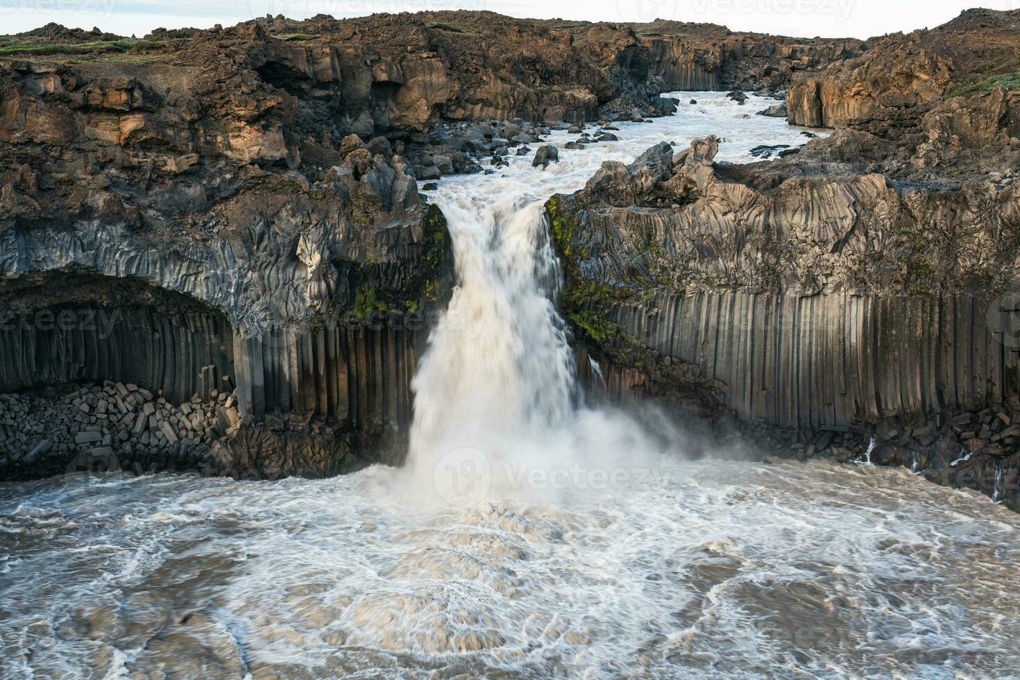 Powerful Aldeyjarfoss waterfall flowing from ancient Badardalshraun lava field and basalt column in summer at Iceland photo