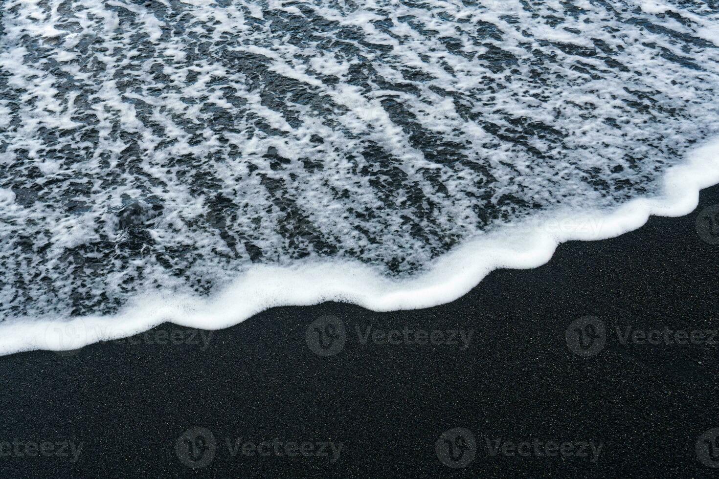Sea wave on volcanic black sand beach in Diamond beach photo