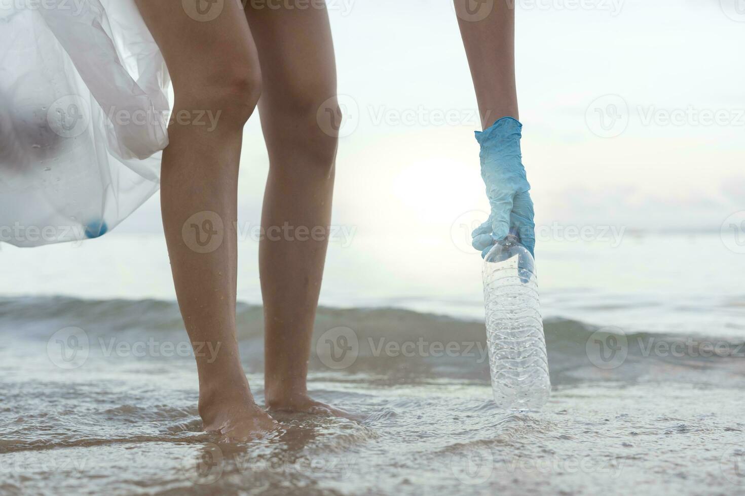 Save ocean. Volunteer pick up trash garbage at the beach and plastic bottles are difficult decompose prevent harm aquatic life. Earth, Environment, Greening planet, reduce global warming, Save world photo