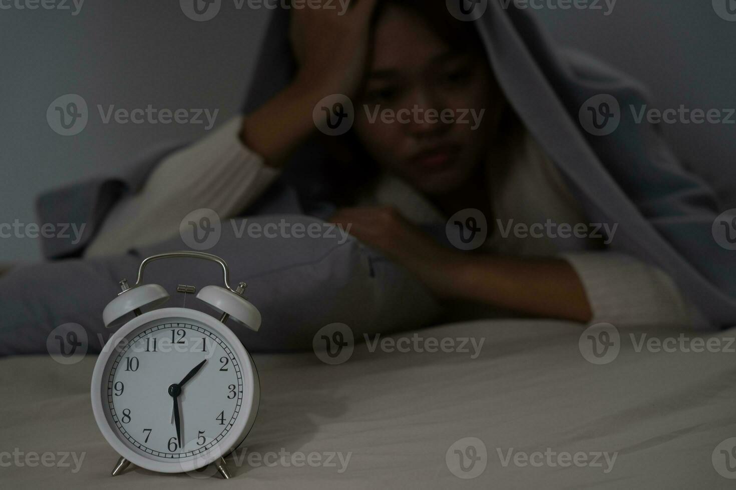 asiático mujer en cama tarde molesto a dormir sufrimiento insomnio, insomne o asustado en un pesadilla, mirando triste preocupado y estresado. cansado y dolor de cabeza o migraña despertar arriba en el medio de el noche. foto