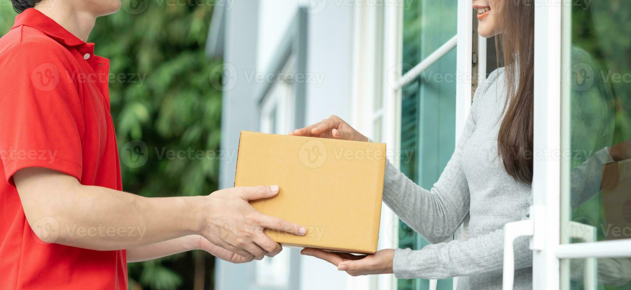 Happy smiling woman receives boxes parcel from courier in front house. Delivery man send deliver express. online shopping, paper containers, takeaway, postman, delivery service, packages photo