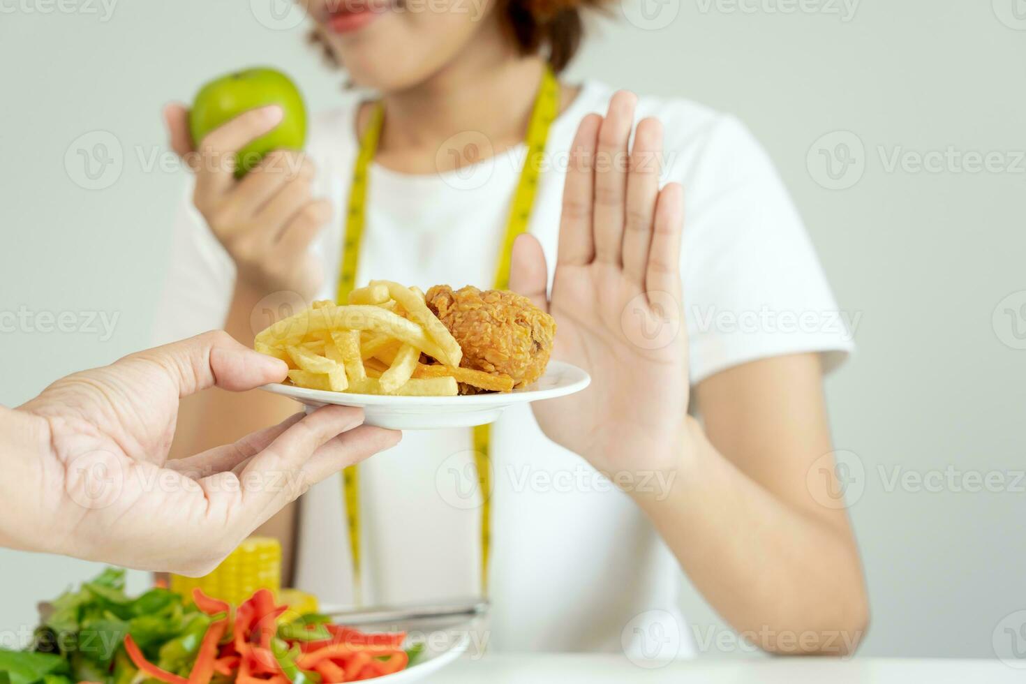 slim female body confuse French fries and fried chicken. Woman in restaurant achieves weight loss goal for healthy life, crazy about thinness, thin waist, nutritionist. Diet, body shape. photo