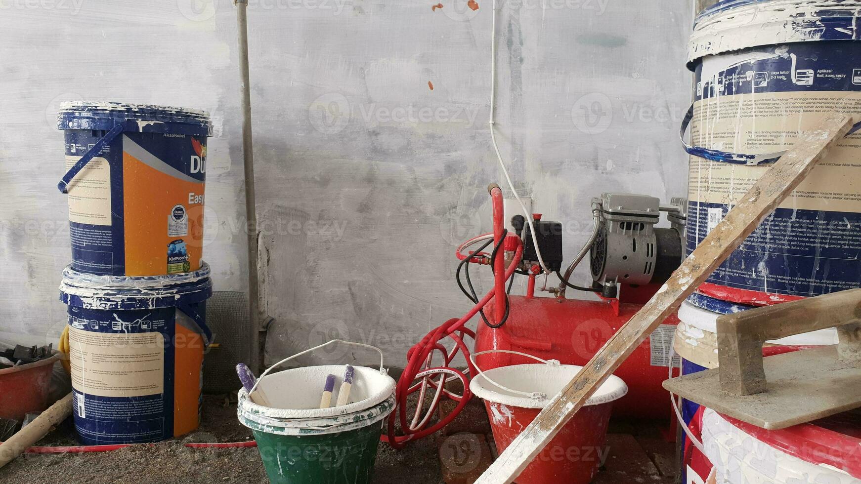 several buckets of used paint and cement for building a house photo