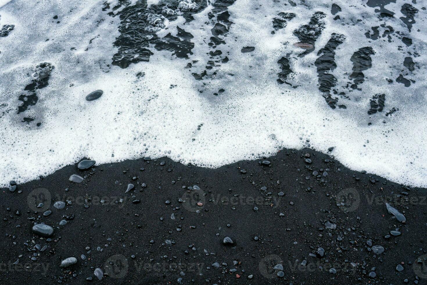 Sea wave on volcanic black sand beach in summer photo