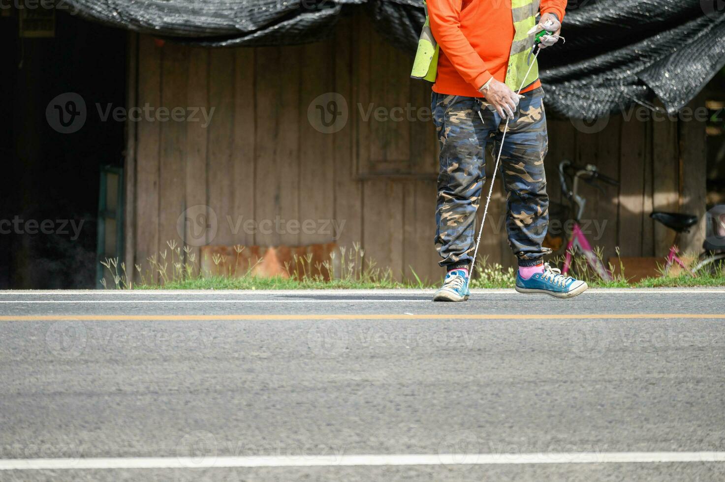 Worker wearing uniform is striping with measuring on the road photo