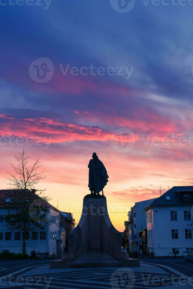 Monument statue of Leif Erikson, a famous Icelandic explorer in front of main entrain the Hallgrimskirkja church in the sunset photo