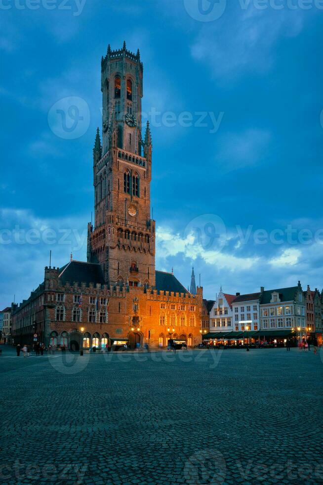 Belfry tower and Grote markt square in Bruges, Belgium on dusk in twilight photo