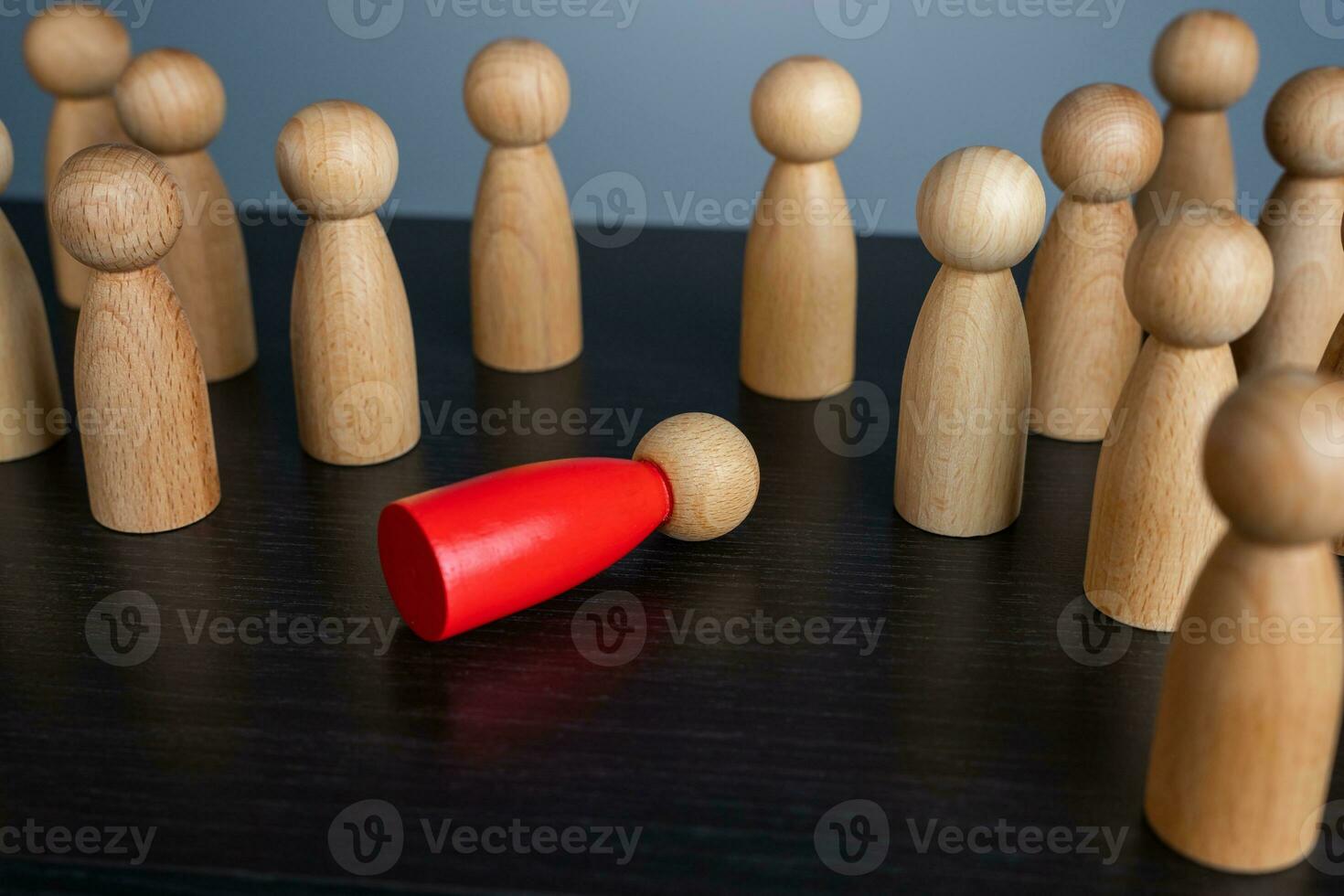 A red man lying in a faint, wooden figurine. Could not stand the load and hardships of work. Working hard. Health problems. Burnout at work. Weak link. Out of order. photo