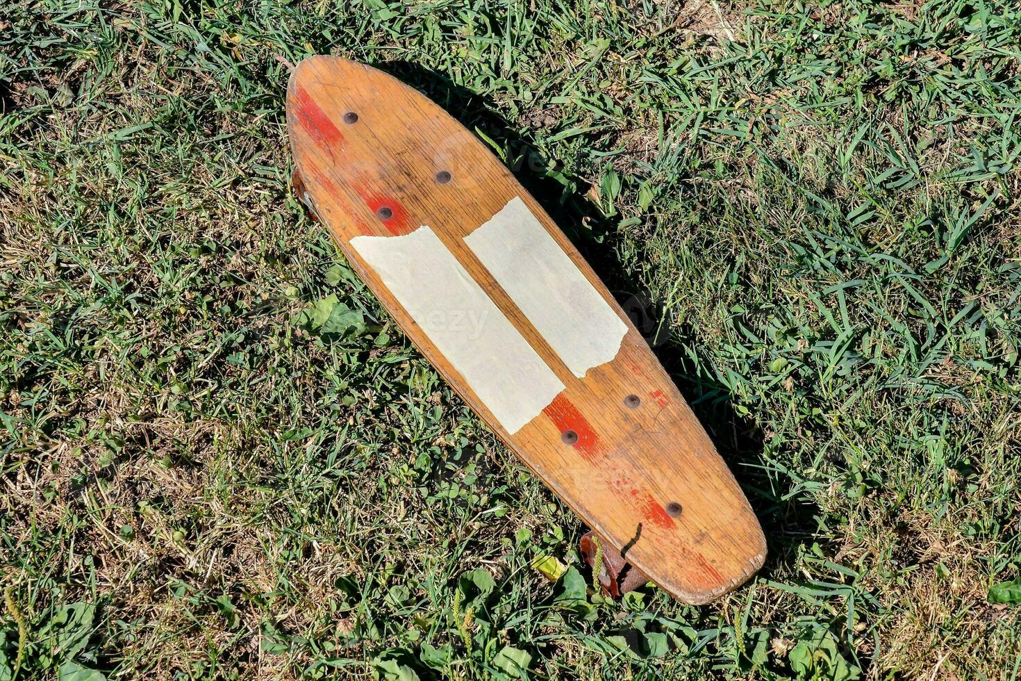 a wooden skateboard laying on the grass photo