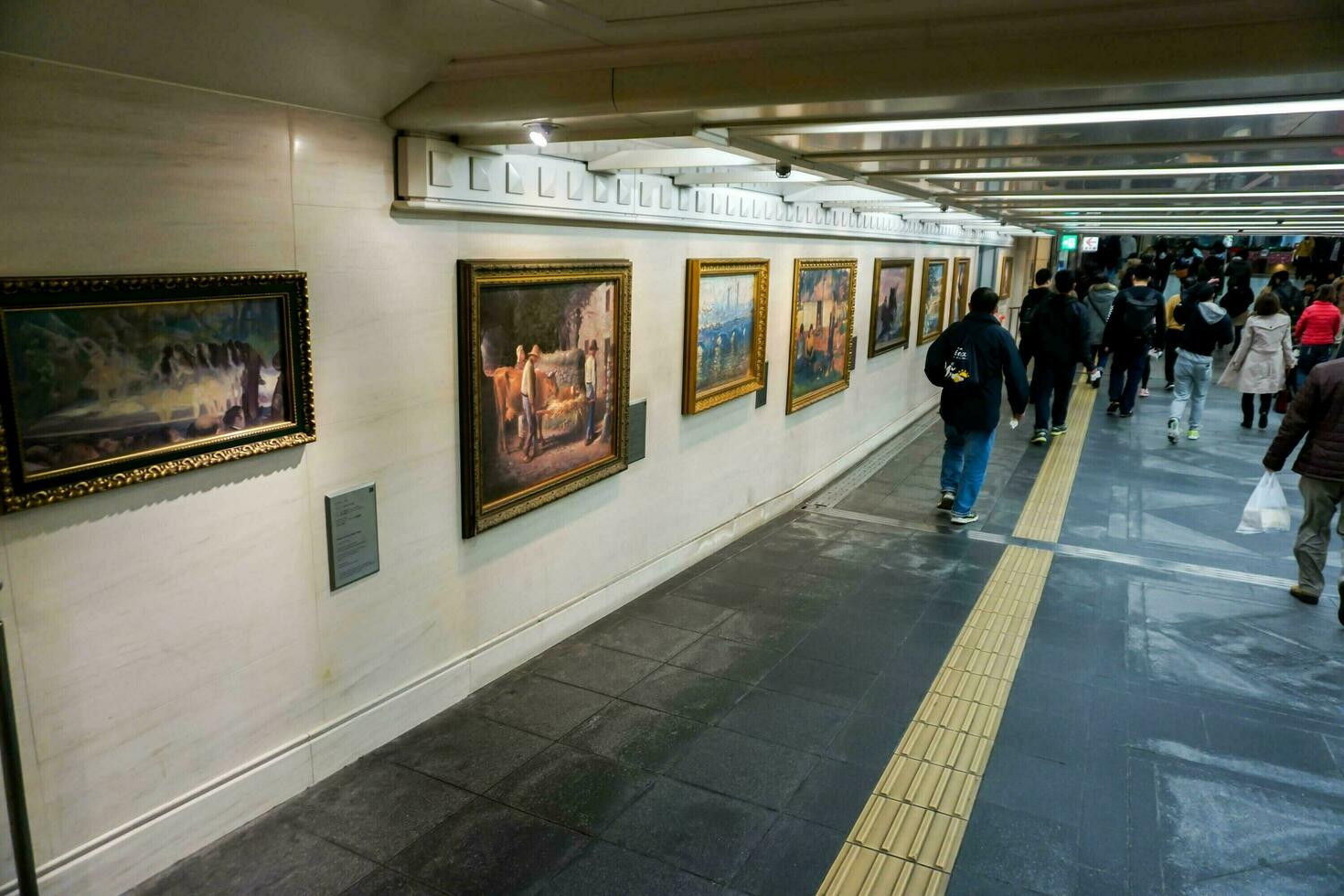 Osaka City, JP, 2019 - Interior and walkway of Osaka subway with row of art picture on the wall. photo