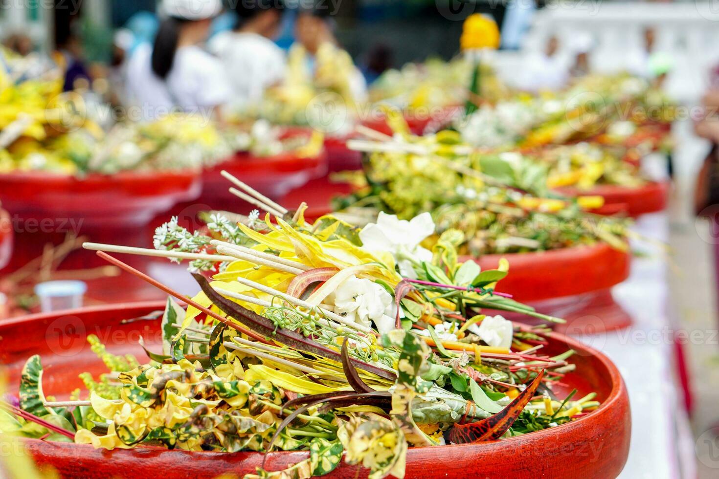 Closeup and crops heap of fragrant flowers with incense on red wooden trays for worship the Buddha in the Thai Lanna dedicate a bouquet of flowers to worship the Buddha tradition. photo