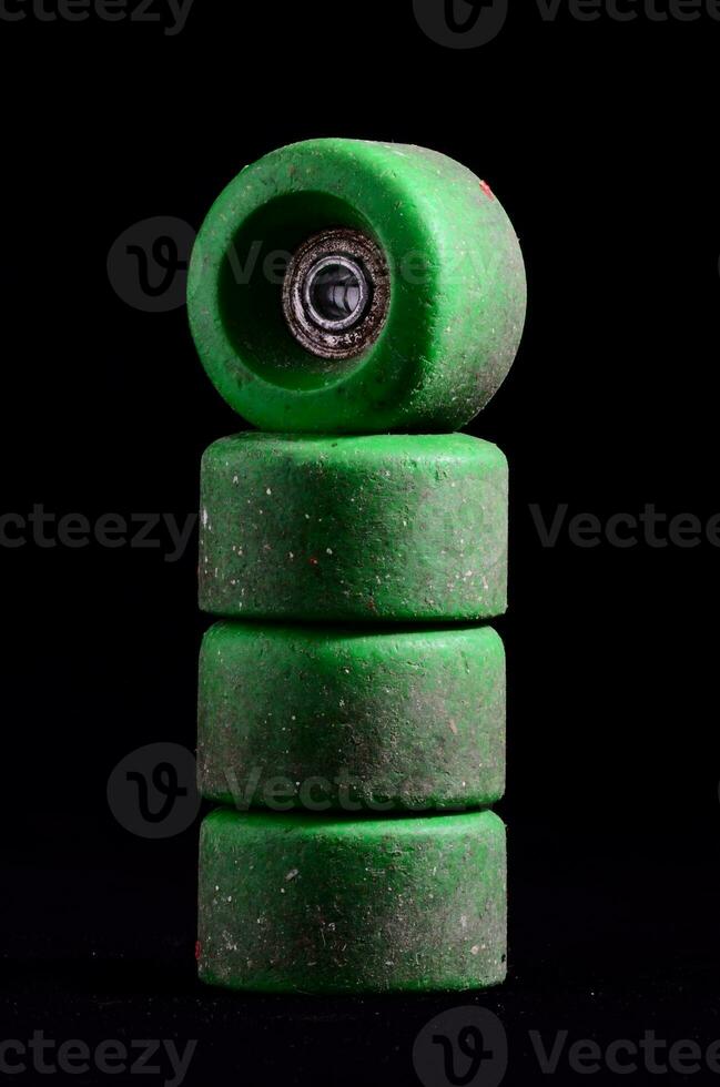 a stack of green skateboard wheels on a black background photo