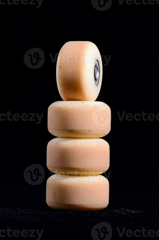 a stack of white skateboard wheels on a black background photo