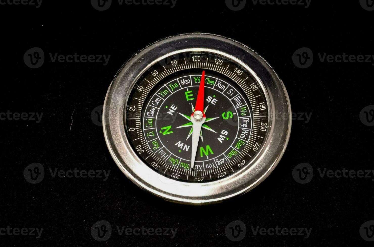 a metal compass with green and black markings photo