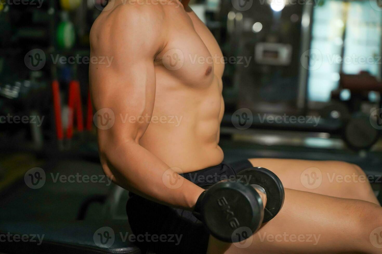 Closeup and crop perfect body of Asian guy playing weight training at fitness center. photo