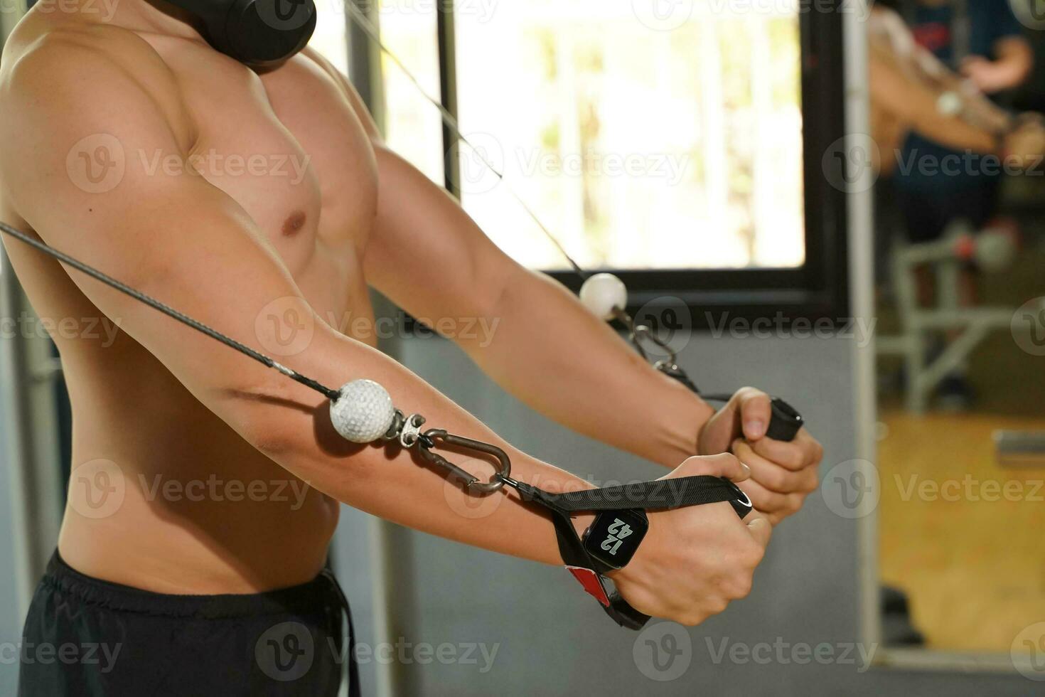 Closeup and crop perfect body of Asian guy playing weight lifting machine at fitness center. photo