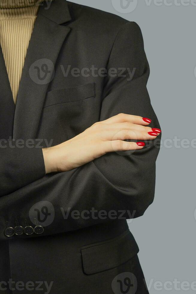 Business lady keeps her hands folded. Red manicure. photo