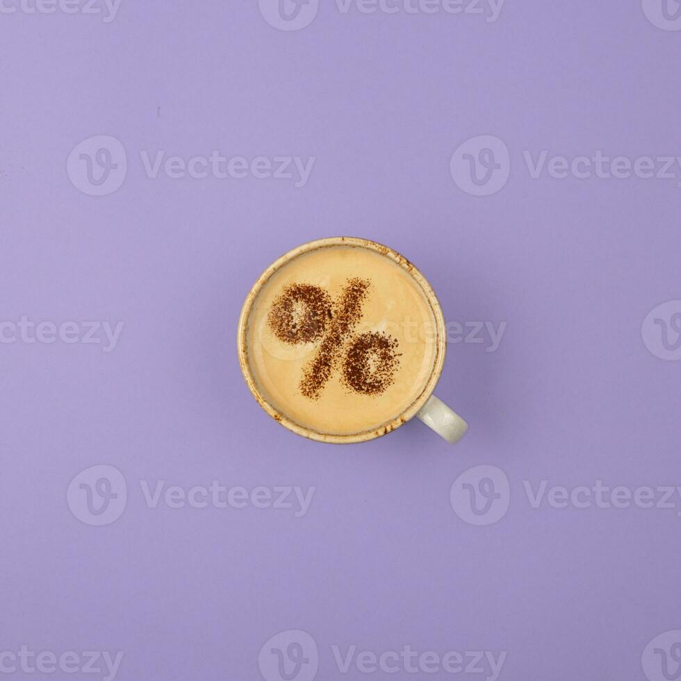 Percentage sign on a cup of coffee. Discount concept. Purple background. photo
