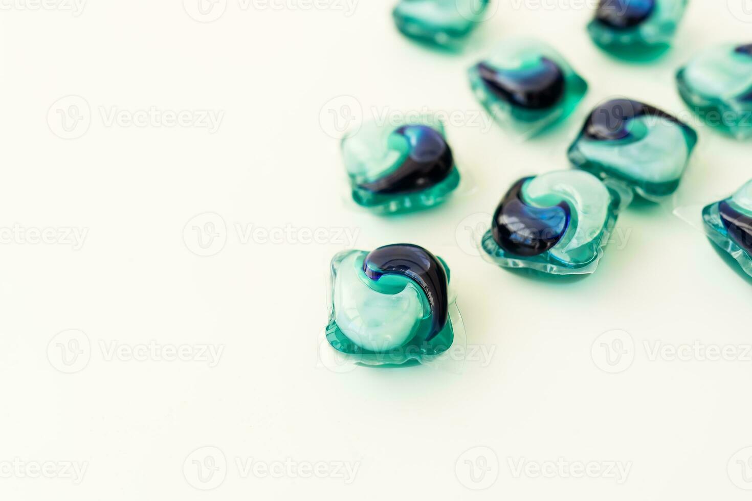 Washing powders in multi-colored capsules on a white background. The concept of washing and cleanliness. Place for an inscription. photo