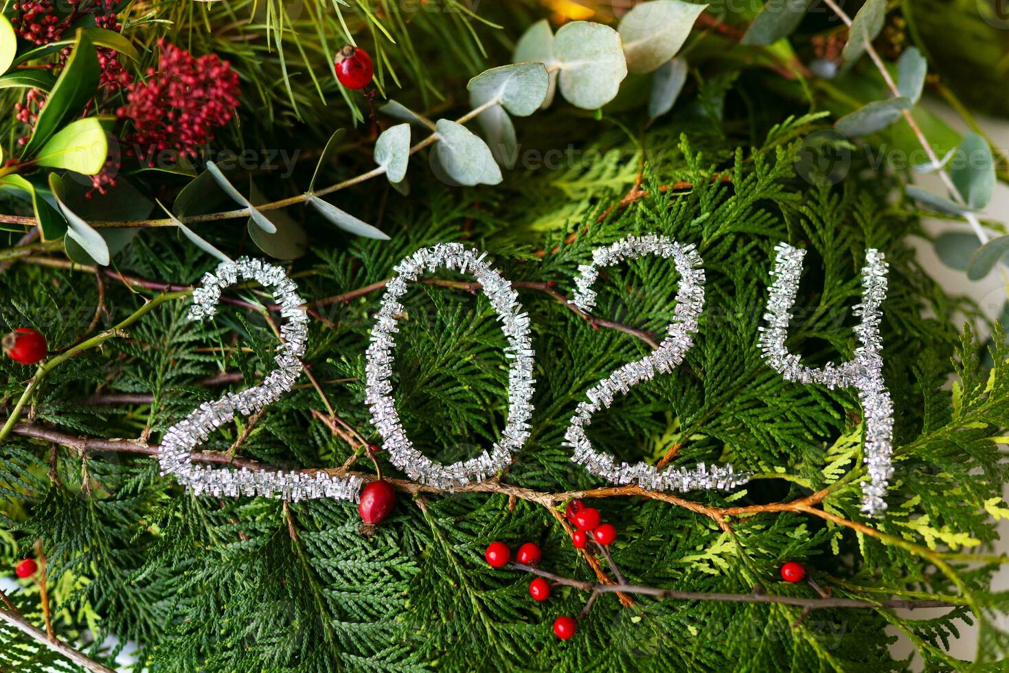 Christmas and New Year concept. The inscription 2024 on pine and fir branches. New Year 2024 idea concept. photo