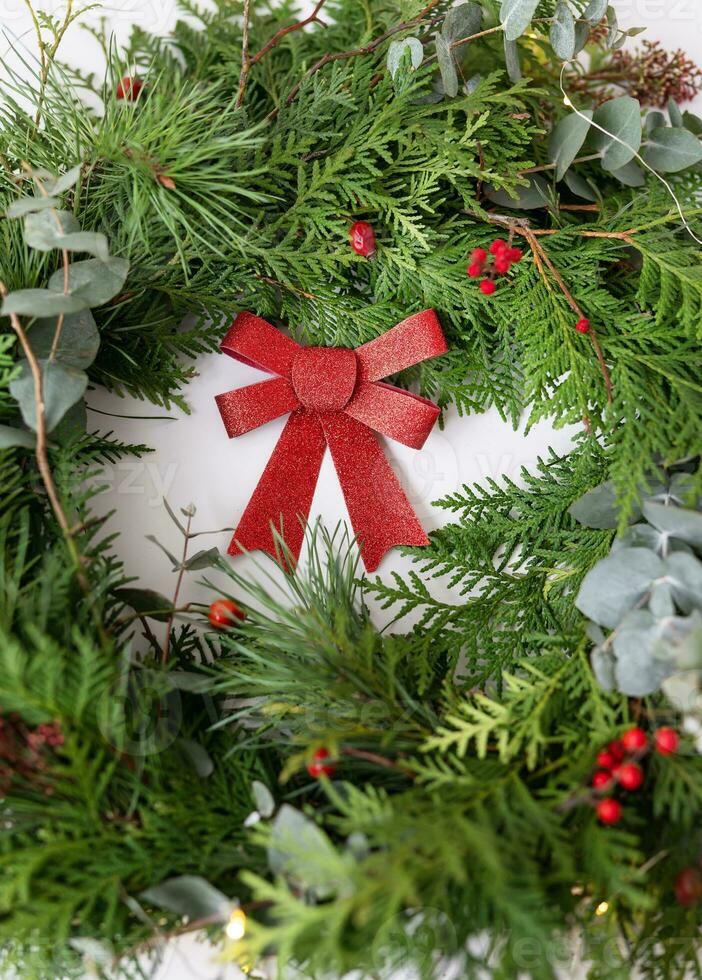 elegante Navidad guirnalda para el interior. hecho a mano guirnalda con un hermosa rojo arco. celebracion atmósfera. foto