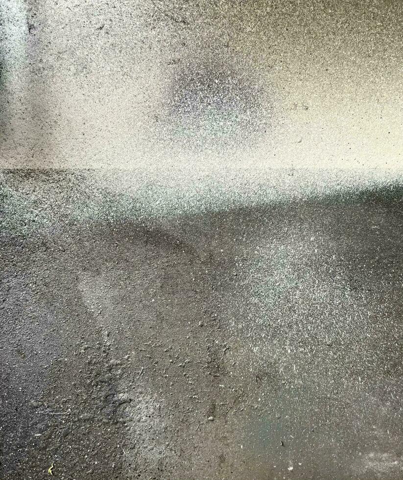 Grungy textured spray painted metal surface with empty no text copy space. Industrial themed background, wallpaper, or backdrop photography. White spray paint stains on dark gray surface. photo