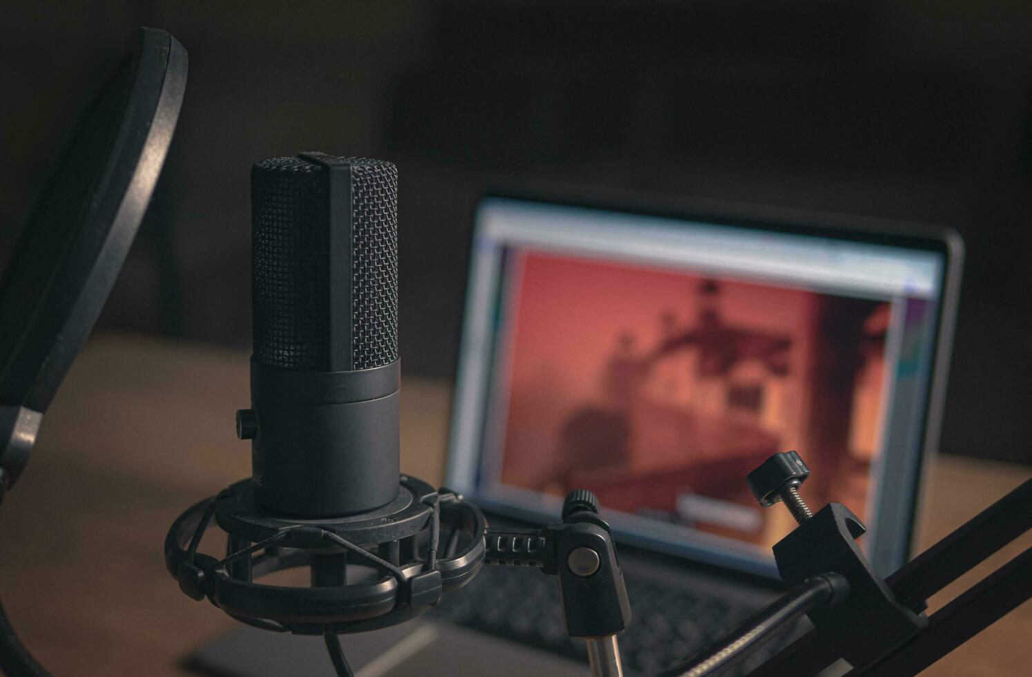 Home studio for podcasts. Large Microphone, laptop and notebooks on the table. Close-up. Cinematic style. new photo