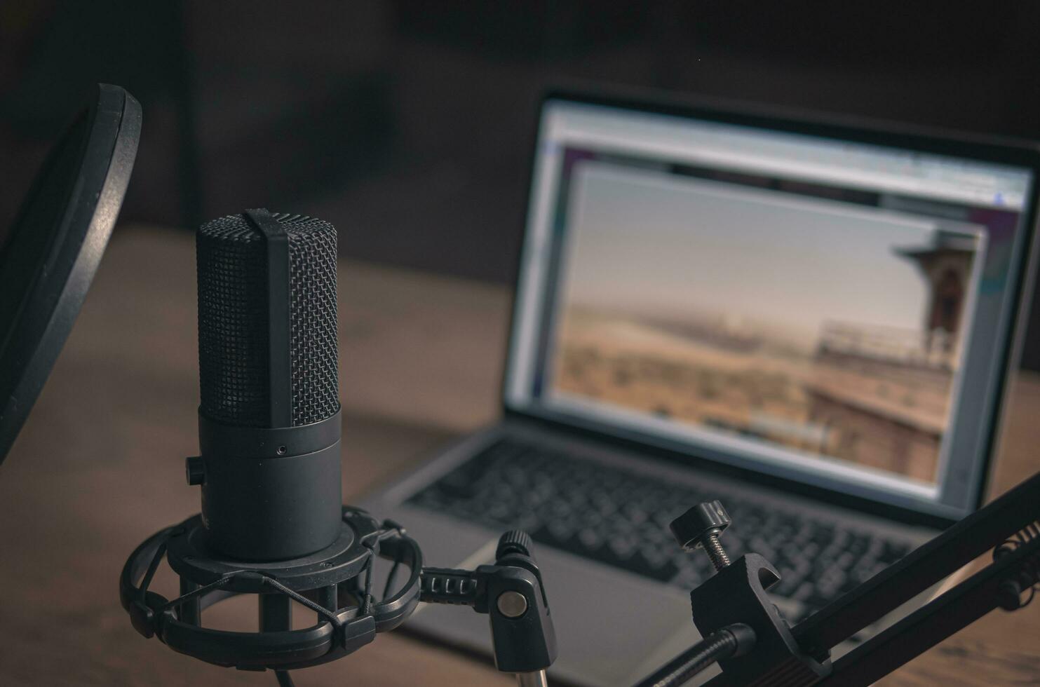 Home studio for podcasts. Large Microphone, laptop and notebooks on the table. Cinematic photo