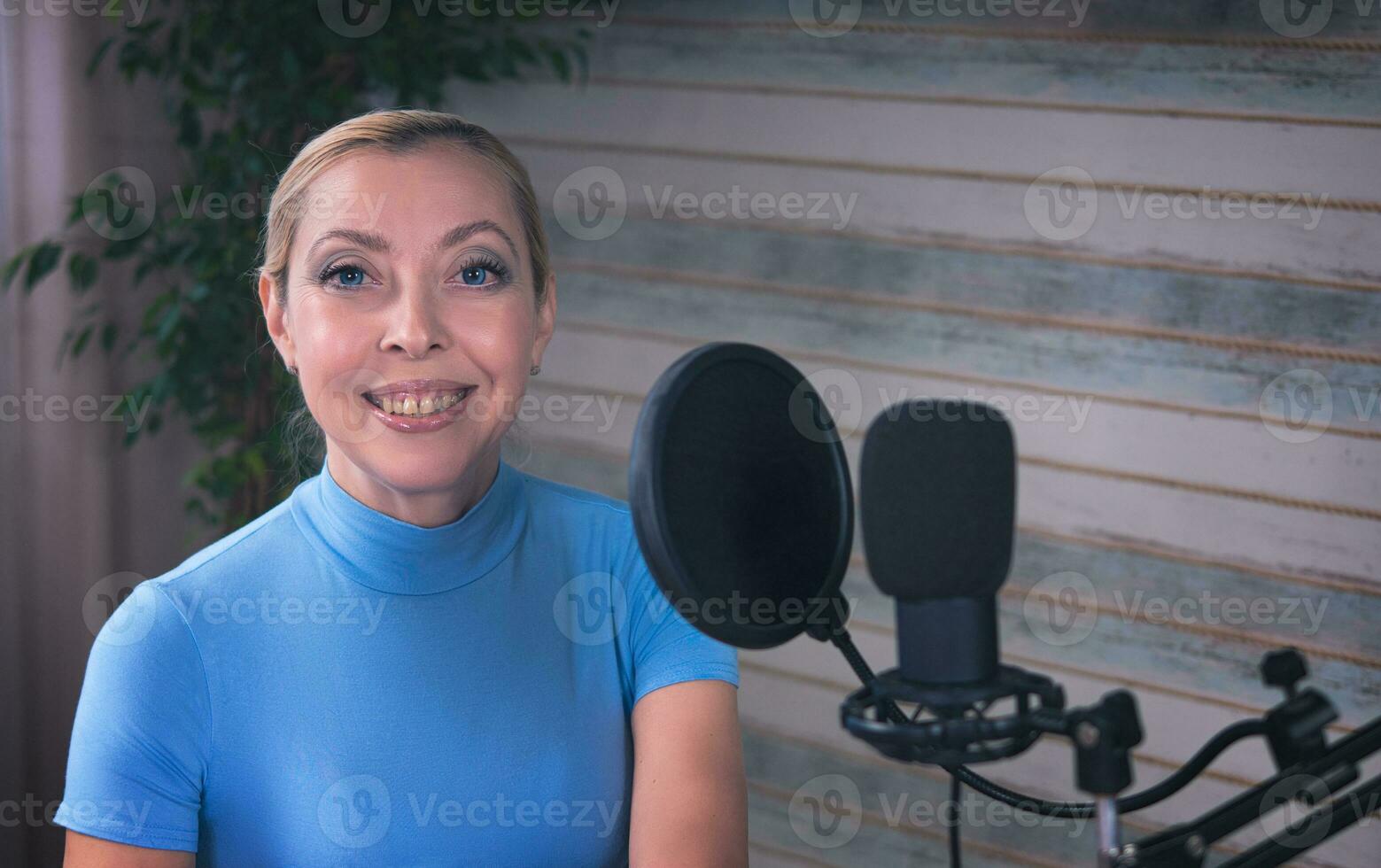 Girl preparing for a podcast with a microphone and ficus in the background photo