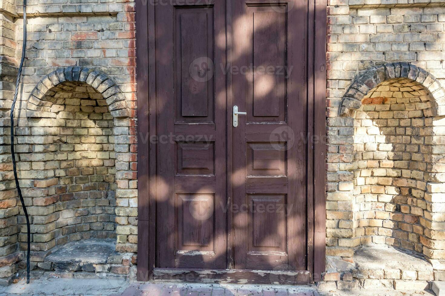 wooden doors to an old brick building photo