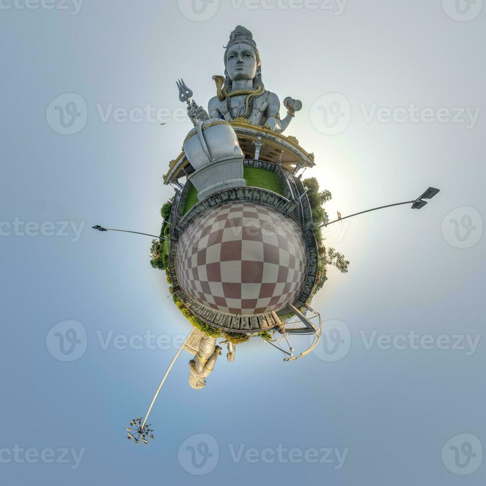 tallest hindu shiva statue in india on mountain near ocean on little planet in blue sky, transformation of spherical 360 panorama. Spherical abstract view with curvature of space. photo