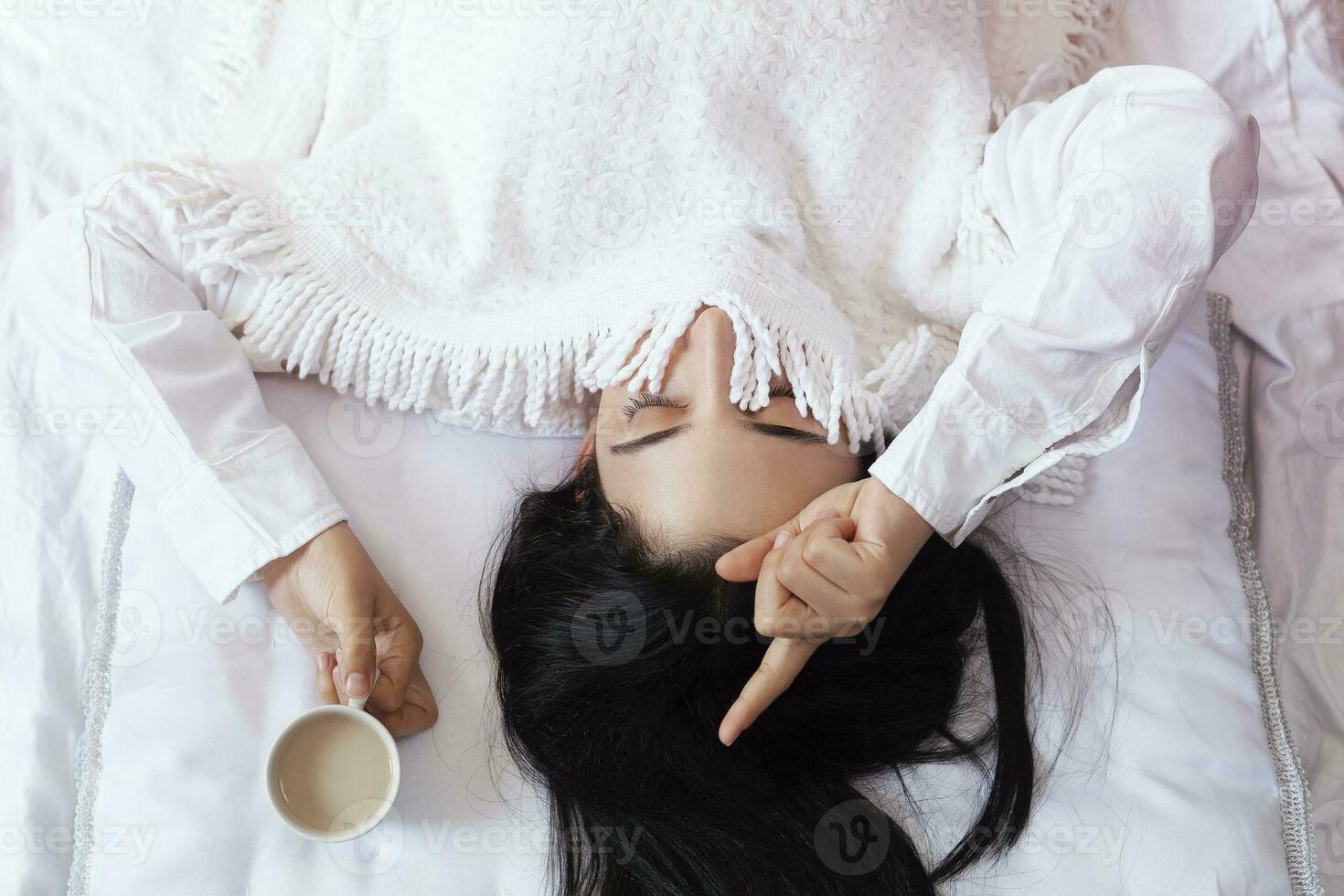 Beauty woman drinking ordering coffee in bed. Female waking up in morning. Young beautiful woman in bed with cup of coffee. Cute lady waking up. Breakfast in cozy bedroom photo