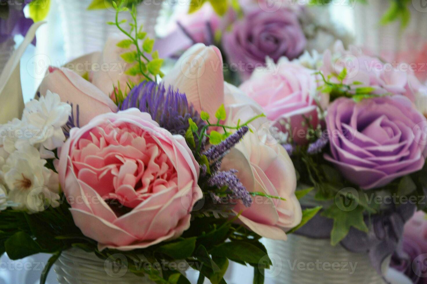 Interior floral arrangement of pink and lilac peonies and roses with green leaves. Beautiful floral background. photo