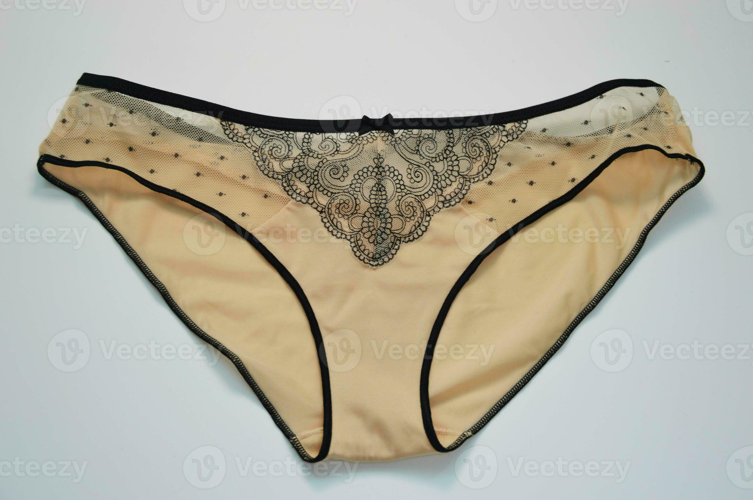 Lingerie. Beautiful silk beige panties with black lace on a white