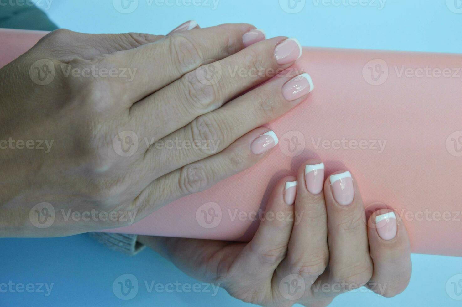 French manicure. Women's hands with beautiful manicured nails. Spa treatments and skin care photo