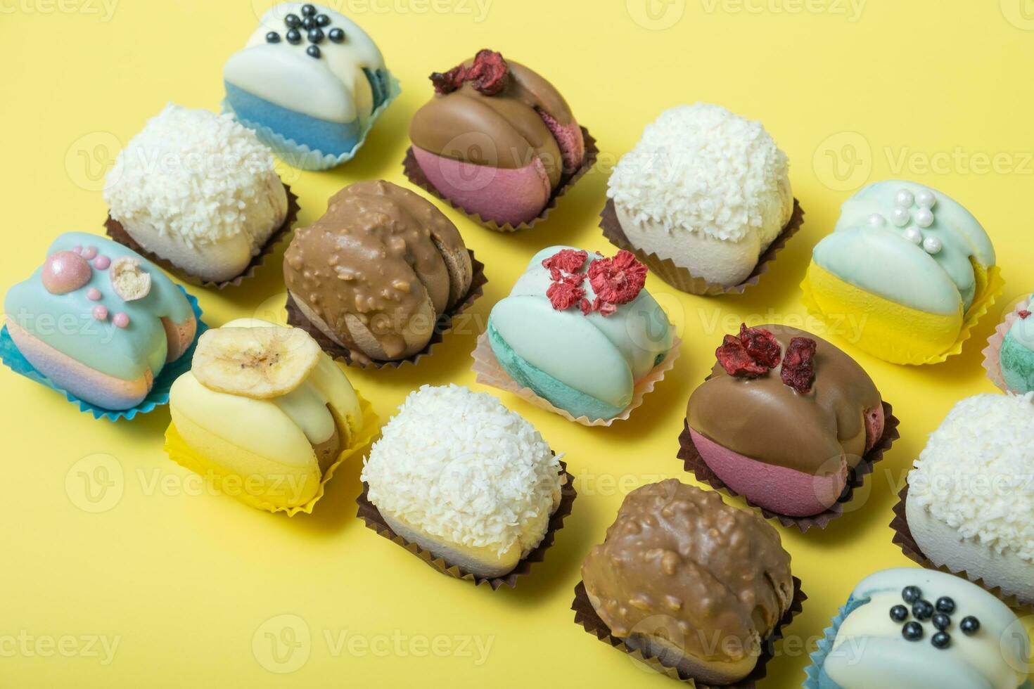 Set of different macaroons on yellow background top view, flat lay photo