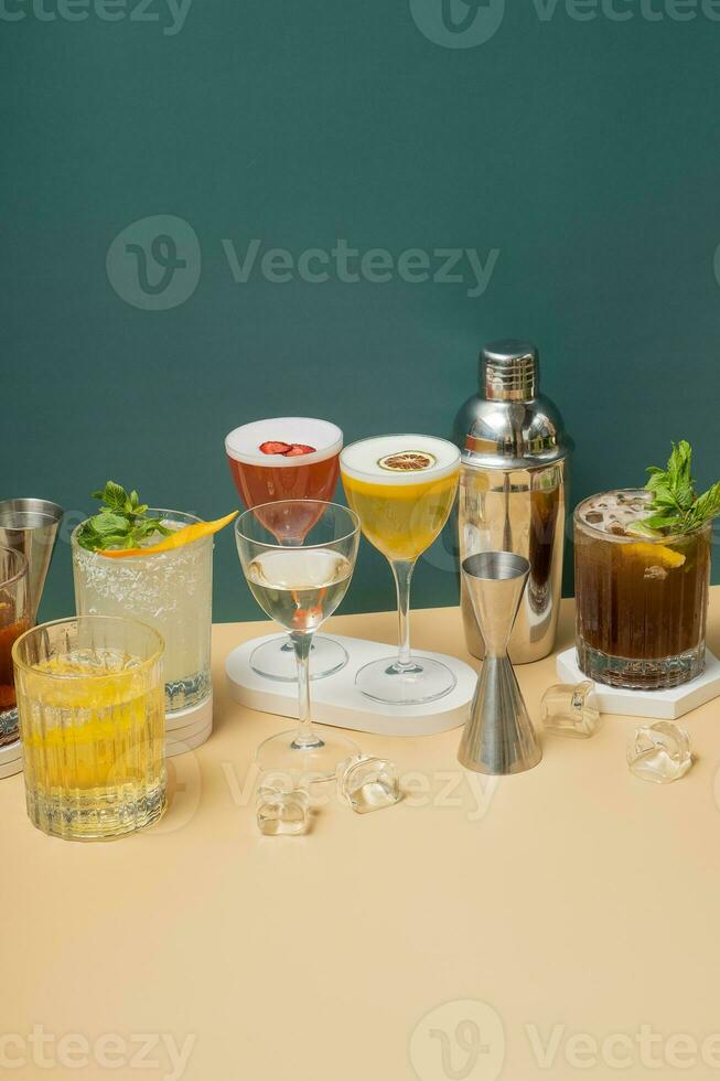 composición con alcohólico cócteles y bar herramientas en podios en de colores antecedentes. foto