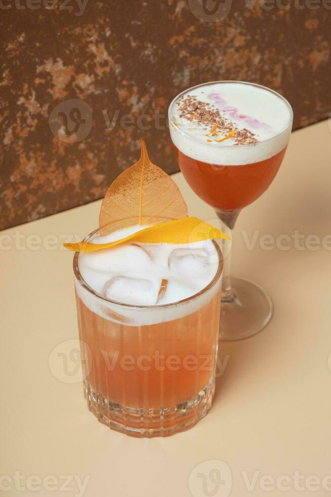 Bright alcoholic cocktails in glasses on beige brown background. photo