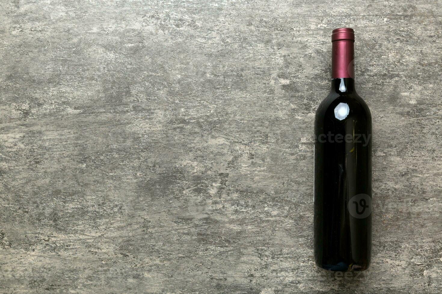 One Bottle of red wine on colored table. Flat lay, top view wth copy space photo