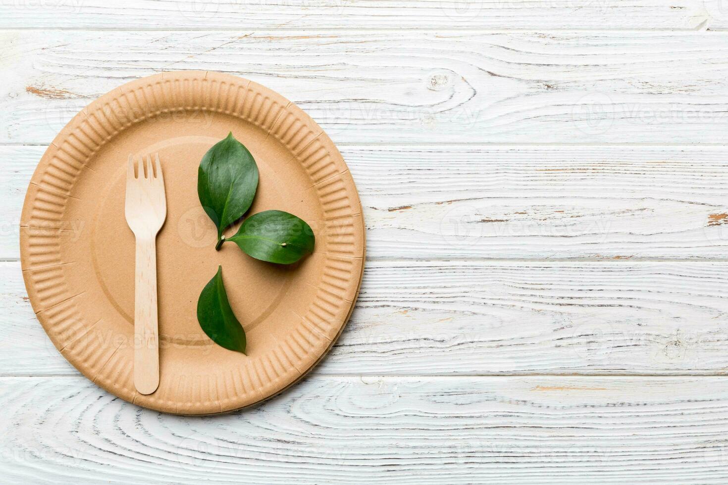 set of empty reusable disposable eco-friendly plates, cups, utensils on light white colored table background. top view. Biodegradable craft dishes. Recycling concept. Close-up photo