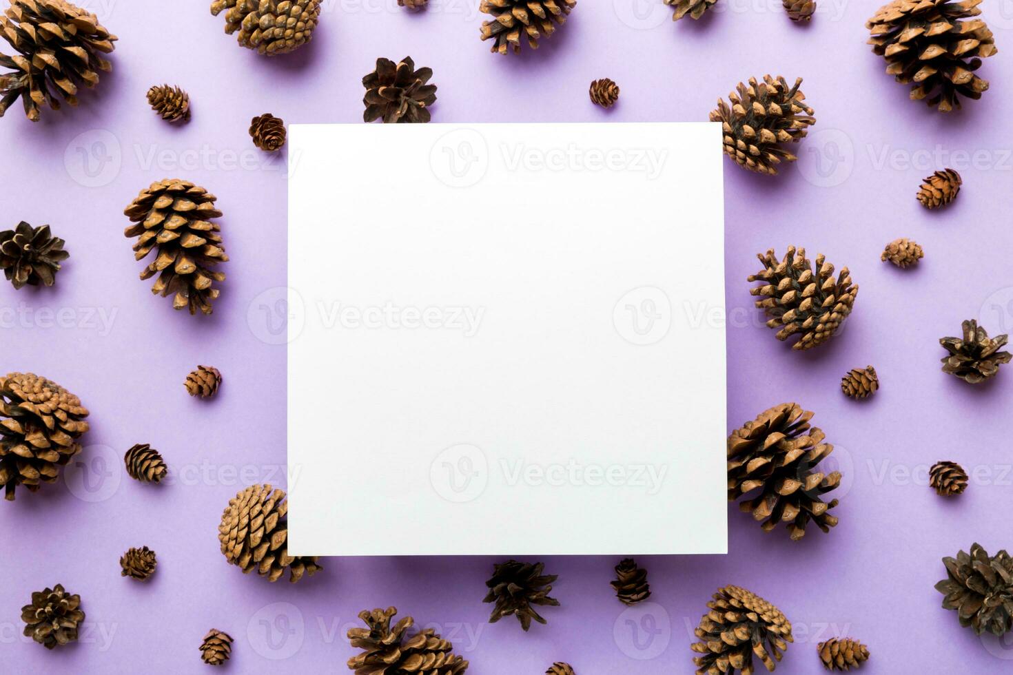 Creative frame made of Christmas pine cones with square Paper blank. Xmas and New Year theme. Flat lay, top view copy space photo