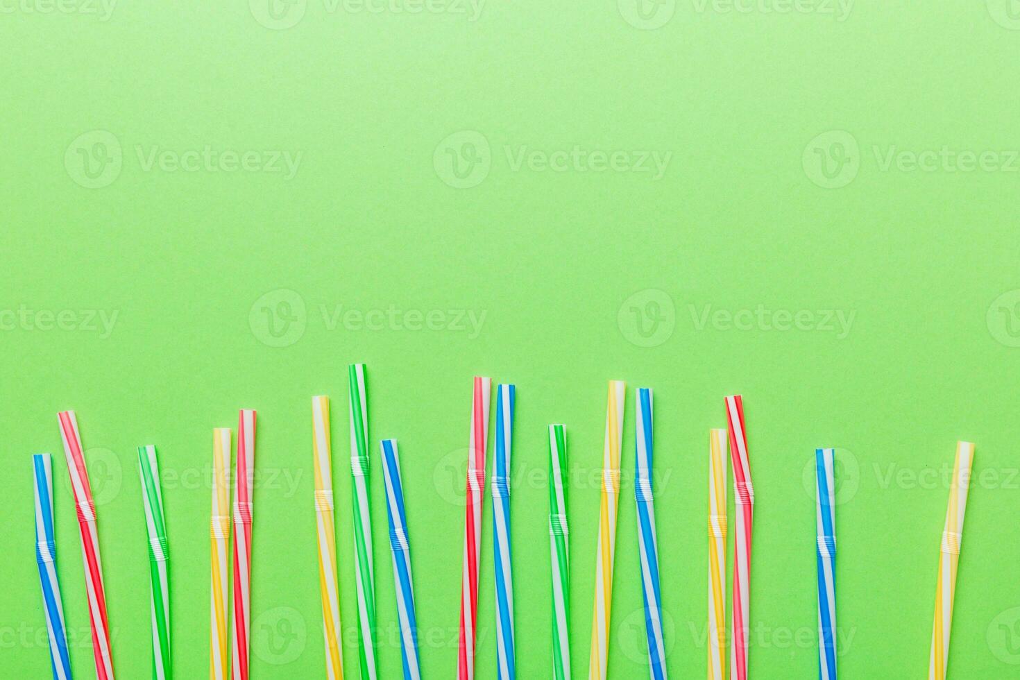 Heap of colorful plastic drinking straws on Colored background, flat lay. Copy Space for text photo