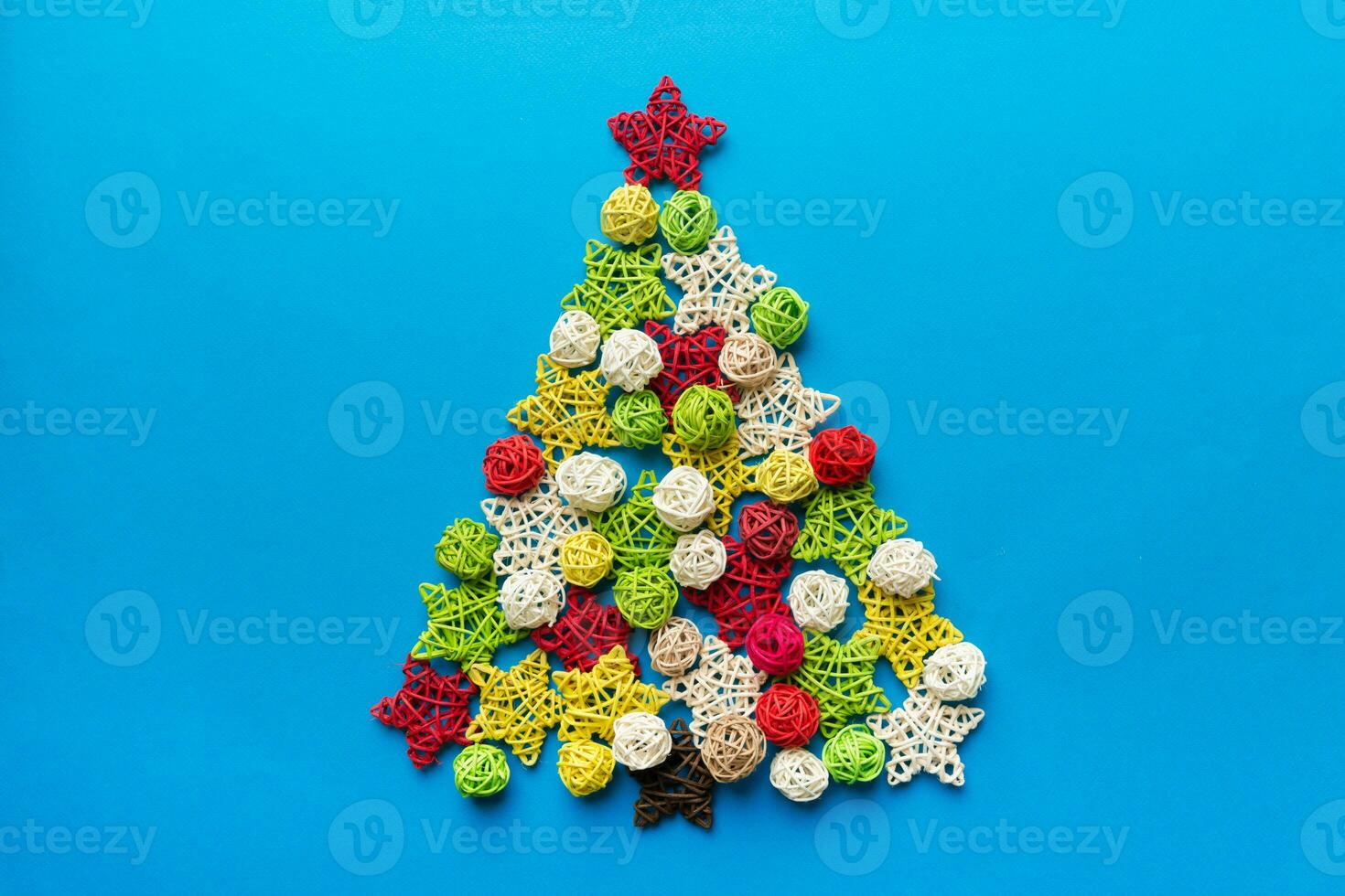 Christmas tree made from colored handmade ball decoration on colored background, view from above. New Year minimal concept with copy space photo