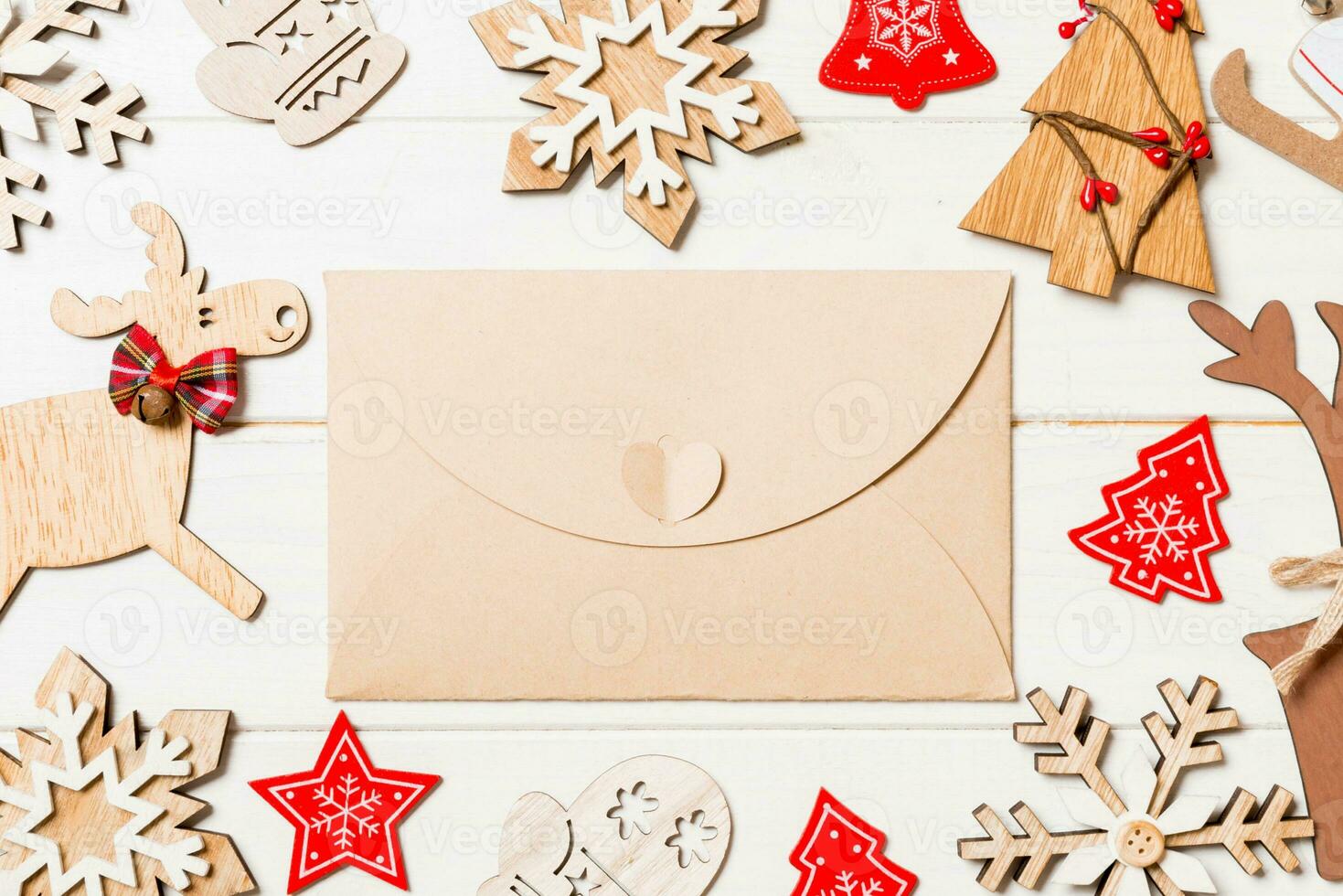 Top view of envelope on festive wooden background. Christmas toys and decorations. New Year time concept photo