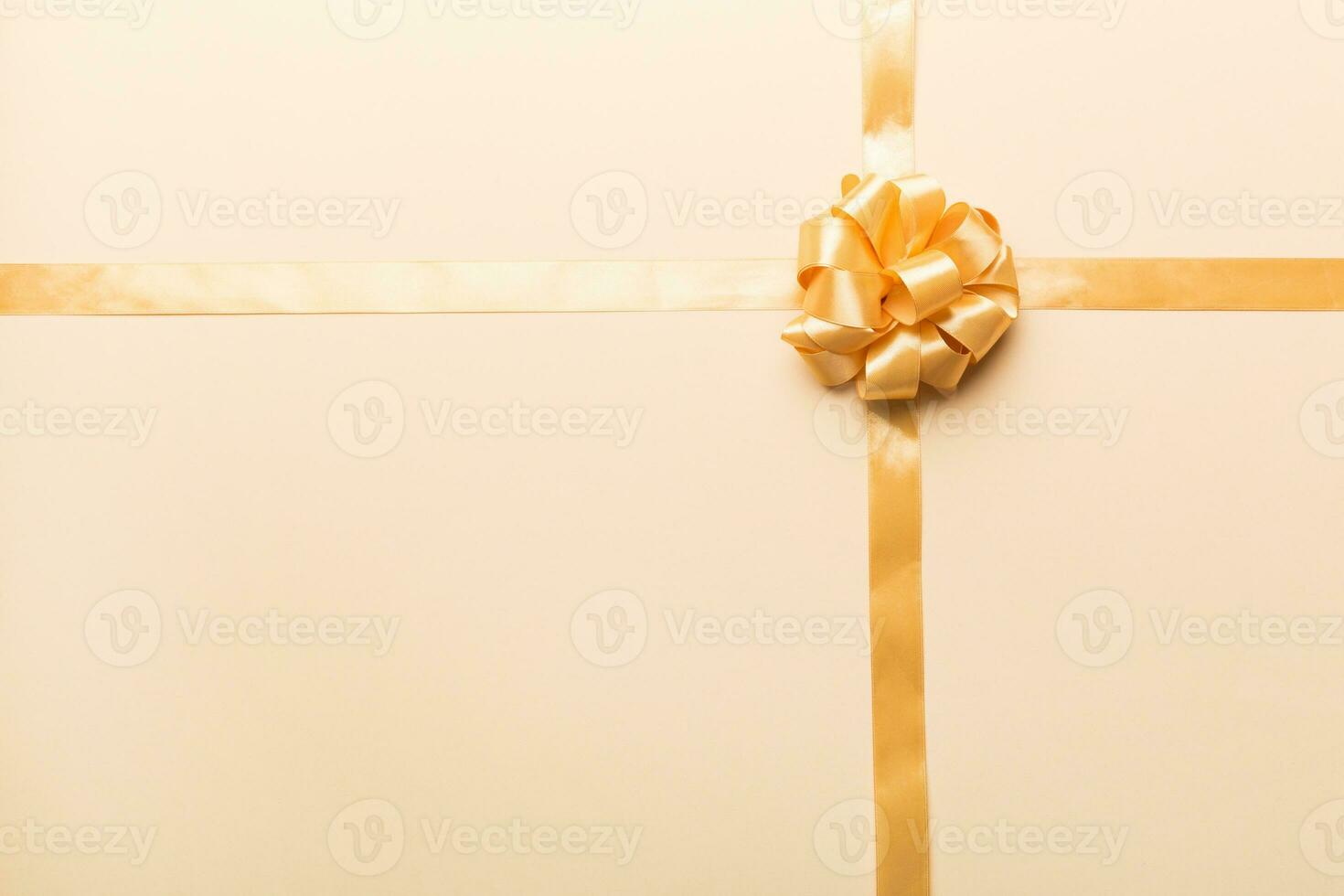 Top view of gold ribbon rolled and yellowbow isolated on colored background. Flat lay with copy space photo