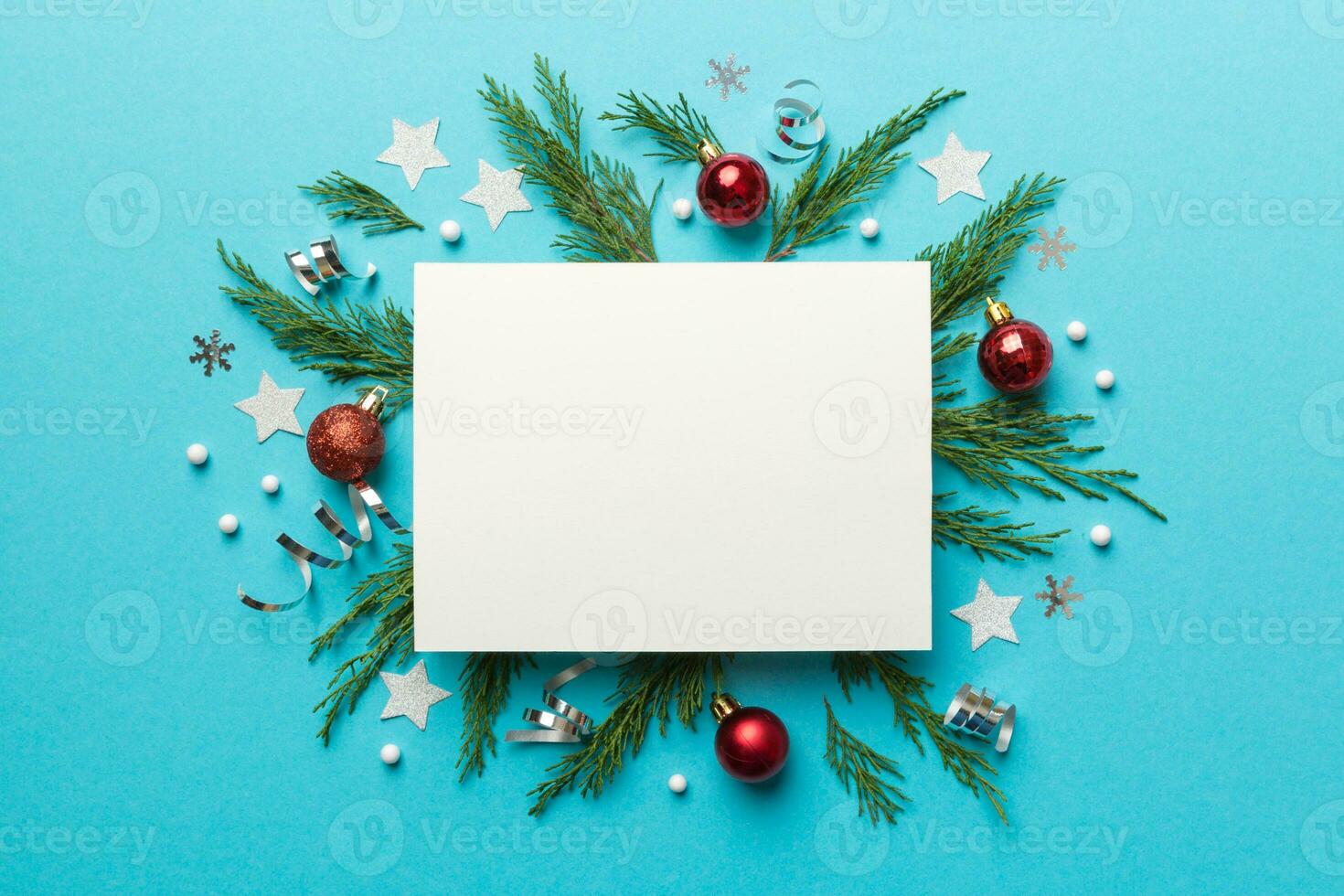 Flat lay Christmas composition. square Paper blank, pine tree branches, christmas decorations on Colored background. Top view, copy space for text photo