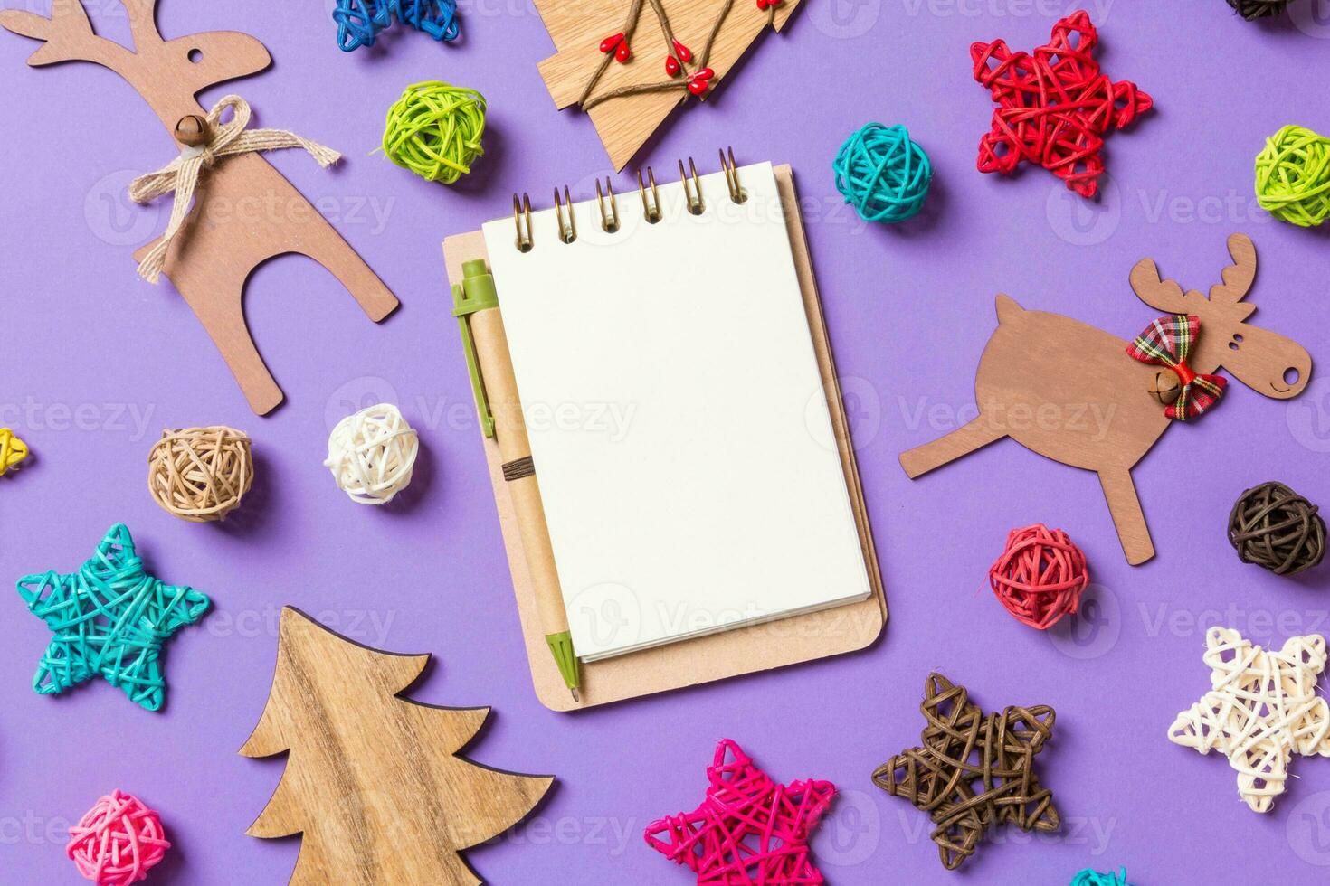 Top view of notebook. New Year decorations on purple background. Festive stars and balls. Merry Christmas concept photo