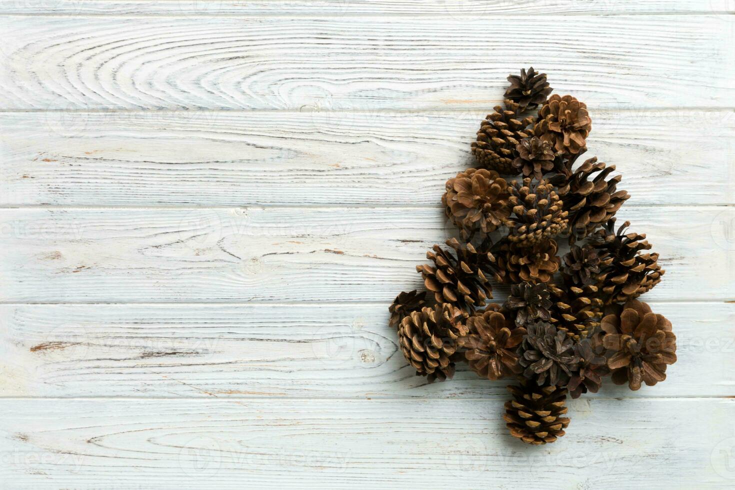 Christmas tree made from natural cones on colored background, view from above. New Year minimal concept with copy space photo
